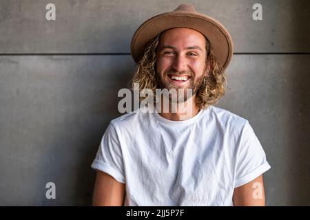 Heureux homme portant un chapeau devant le mur Banque D'Images