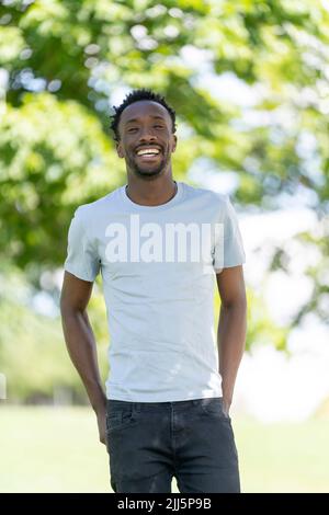 Jeune homme heureux debout dans le parc Banque D'Images