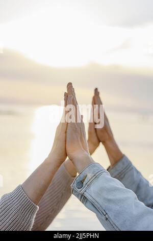 Petite amie et petit ami se touchant les mains au coucher du soleil Banque D'Images