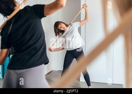 Instructeur de fitness enseignant le stick yoga au club de santé Banque D'Images