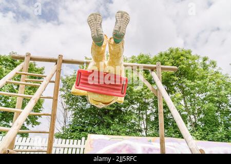 Petite fille balançant sur l'aire de jeux Banque D'Images