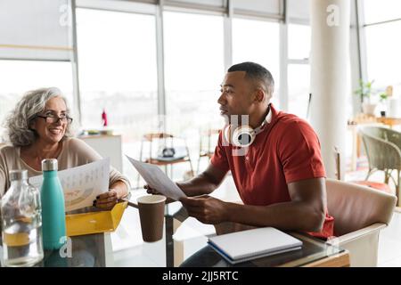 Bonne femme d'affaires senior discutant du travail avec un collègue au bureau Banque D'Images