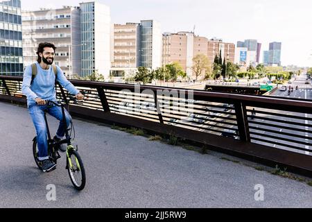 Homme souriant à vélo sur la passerelle Banque D'Images