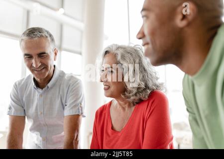 Heureux homme d'affaires mature assis avec des collègues Banque D'Images