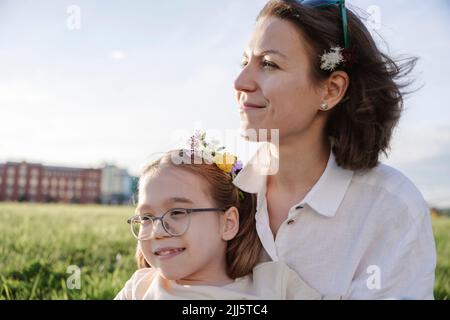 Mère souriante avec fille au parc le jour ensoleillé Banque D'Images