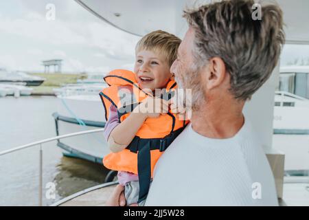 Beau père portant son fils sur le balcon de la péniche Banque D'Images