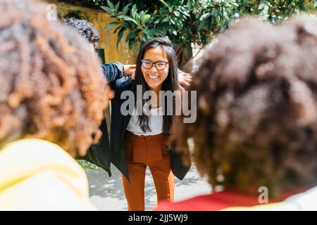 Bonne femme d'affaires par des collègues multiraciaux Banque D'Images