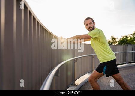 Homme barbu qui s'étire sur la passerelle Banque D'Images