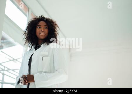 Femme souriante médecin avec des cheveux bouclés Banque D'Images