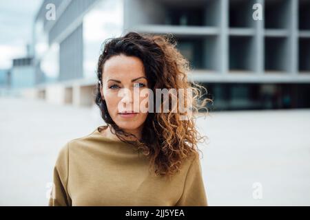 Femme d'affaires confiante aux cheveux bouclés Banque D'Images