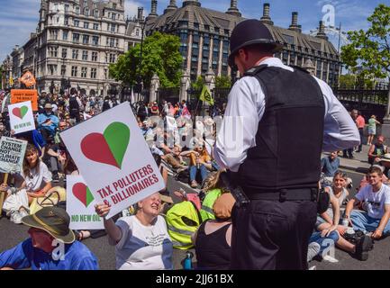 Londres, Royaume-Uni. 23rd juillet 2022. Un policier parle à un manifestant sur la place du Parlement. Les manifestants de Just Stop Oil, la rébellion contre l'extinction, isolent la Grande-Bretagne et d'autres groupes ont organisé une marche dans le centre de Londres appelant le gouvernement à mettre fin aux combustibles fossiles, à taxer les grands pollueurs et les milliardaires, à fournir une isolation pour toutes les maisons et à agir sur le climat et les crises du coût de la vie. Credit: Vuk Valcic/Alamy Live News Banque D'Images