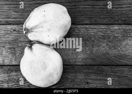 Coings isolés. Deux coings jaune sur une planche de bois. Banque D'Images