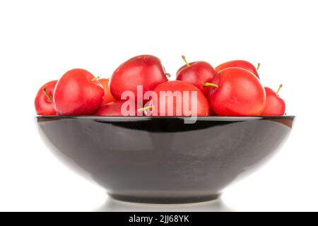 Plusieurs prunes mûres de cerise juteuse dans une plaque en céramique noire, en gros plan, isolées sur un fond blanc. Banque D'Images