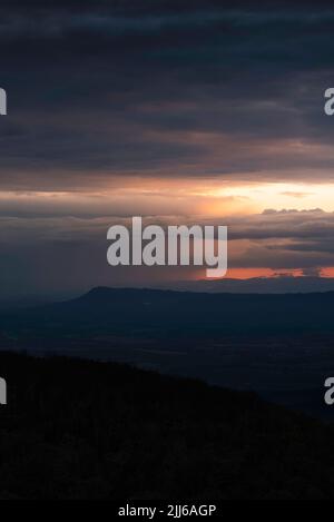 Un coucher de soleil spectaculaire illumine les dégrins et les nuages de tempête lointains à travers la vallée de Shenandoah et derrière la montagne Massanutten. Banque D'Images