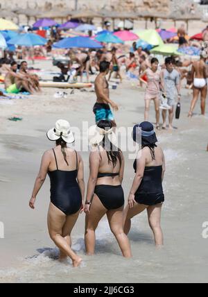 Cala Major, Espagne. 23rd juillet 2022. Les gens se trouvent sur la plage de Cala Major, près de Palma sur Majorque, et trois femmes marchent à travers l'eau. Sur l'île de vacances espagnole, non seulement le sable et l'air sont très chauds ces jours-ci, mais aussi l'eau de mer atteint des températures exceptionnellement élevées. (À dpa chaleur sur Majorque - mer avant que le 'Ballermann' devienne le bouillon chaud) crédit: Clara Margais/dpa/Alay Live News Banque D'Images