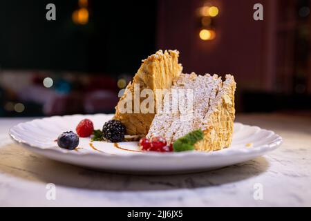 gâteau napoléon aux baies sur une assiette blanche. dessert servi dans un restaurant. Banque D'Images