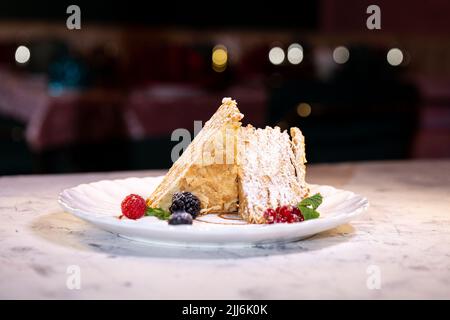 gâteau napoléon aux baies sur une assiette blanche. dessert servi dans un restaurant. Banque D'Images