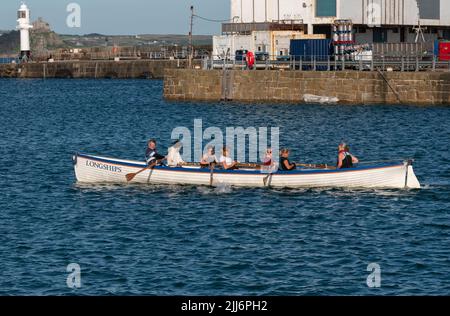 Penzance, Cornwall, Angleterre, Royaume-Uni. 2022. The Longships un pilote d'entraînement et une équipe d'aviron sur le port de Penzance, Cornwall, Royaume-Uni Banque D'Images