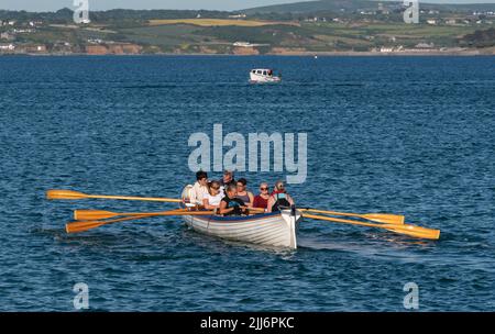 Penzance, Cornwall, Angleterre, Royaume-Uni. 2022. The Longships un pilote d'entraînement et une équipe d'aviron avec une vue sur la côte de Cornouailles près de Penzance, Cornwall, Royaume-Uni Banque D'Images