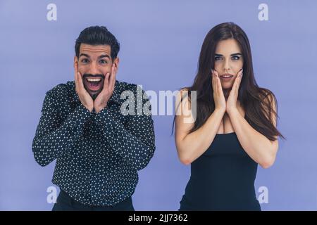 Un couple choqué - beau cubain et jeune caucasien à poil long - se touchant le visage et ouvrant la bouche. Offre étonnamment bonne. Espace de copie Studio shot. Photo de haute qualité Banque D'Images