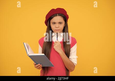 grave adolescente en béret français faisant des notes dans le bloc-notes ou le bloc-notes de planificateur, étudier Banque D'Images