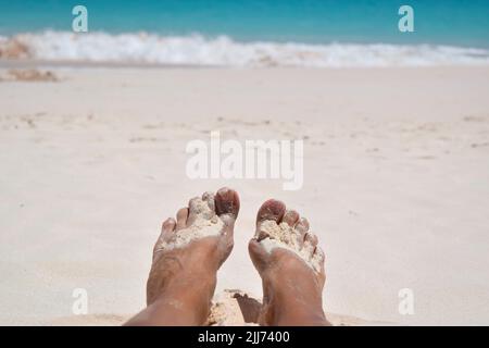 Pieds de dame dans le sable blanc chaud et doux sur la plage de la Barbade. Banque D'Images