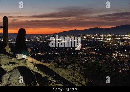 Lone female regarde le coucher du soleil sur la vallée de Los Angeles Banque D'Images