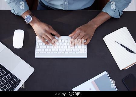 Ses horaires sont occupés aujourd'hui. Prise de vue en grand angle d'un homme d'affaires méconnaissable utilisant un clavier au travail. Banque D'Images