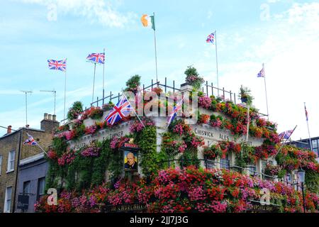 Londres, Royaume-Uni, 23rd juillet 2022. La façade du bâtiment du pub Churchill Arms de Kensington est décorée avec plus de 48 boîtes à fenêtre et 42 paniers suspendus remplis de plantes de literie d'été vibrantes. Le pub, connu pour ses magnifiques expositions saisonnières toute l'année, y compris les arbres de Noël en décembre, est populaire auprès des utilisateurs des médias sociaux. Les arrangements élaborés ont valu à l'établissement plusieurs prix de la London Gardens Society et du Chelsea Flower Show. Crédit : onzième heure Photographie/Alamy Live News Banque D'Images
