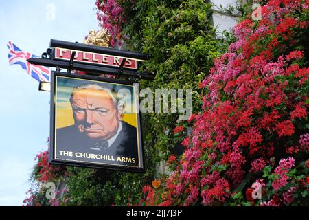 Londres, Royaume-Uni, 23rd juillet 2022. La façade du bâtiment du pub Churchill Arms de Kensington est décorée avec plus de 48 boîtes à fenêtre et 42 paniers suspendus remplis de plantes de literie d'été vibrantes. Le pub, connu pour ses magnifiques expositions saisonnières toute l'année, y compris les arbres de Noël en décembre, est populaire auprès des utilisateurs des médias sociaux. Les arrangements élaborés ont valu à l'établissement plusieurs prix de la London Gardens Society et du Chelsea Flower Show. Crédit : onzième heure Photographie/Alamy Live News Banque D'Images