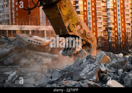 Broyeur de béton travaille avec pile de pierres de ciment de proximité Banque D'Images