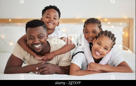 Rien de tel que la gratitude des enfants et l'amour des femmes. Une belle jeune famille se liant dans le lit ensemble. Banque D'Images