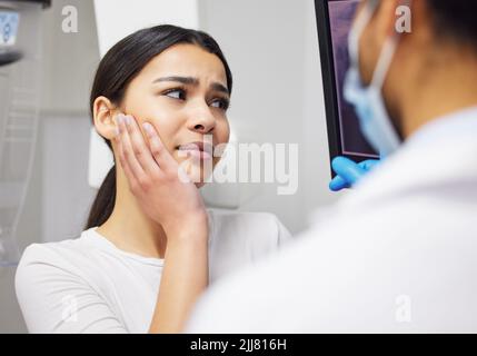 La chirurgie est la seule façon d'avancer. Un dentiste discutant des résultats d'un patient dents x rayon. Banque D'Images