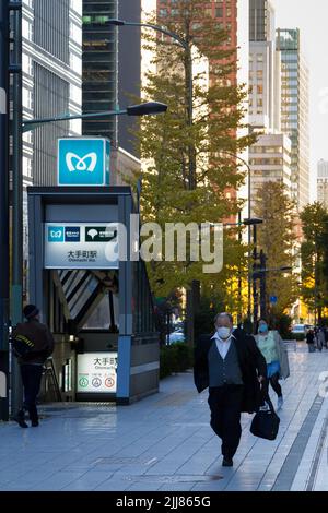 Un salaryman japonais, portant un masque chirurgical contre COVID19 infections marche dans la rue à Otemachi, Tokyo, Japon. Banque D'Images