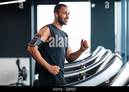 Beau Balck musclé Guy jogging sur un tapis roulant à la salle de gym Banque D'Images