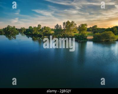 Canards se rassemblant sur le miroir du lac. Soirée sur le lac au soleil couchant Banque D'Images
