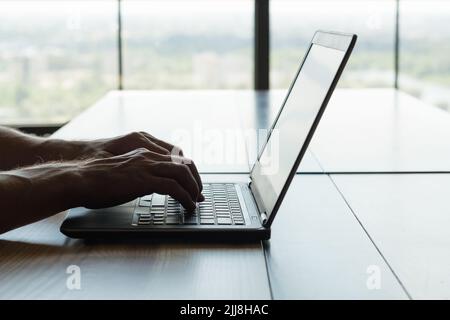 travail indépendant travail à distance portable homme dactylographiant les mains Banque D'Images