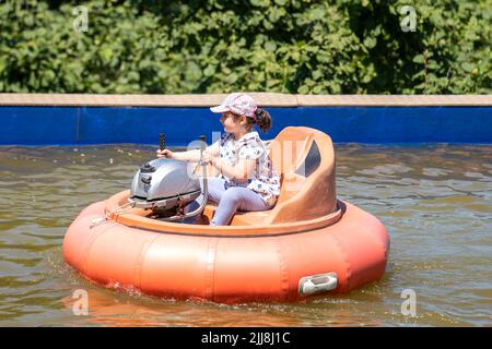 Fille ayant un plaisir dans le parc aquatique avec des bateaux tamponneurs. Banque D'Images