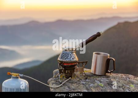 Café au sommet de la montagne. Cafetière bouloteuse sur une pierre avec vue imprenable sur la montagne. Banque D'Images