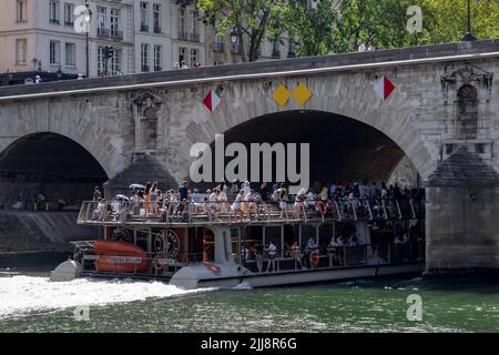 Paris / France - 28 juin 2019 : un bateau de croisière plein de touristes passant sous le pont de la Seine Banque D'Images