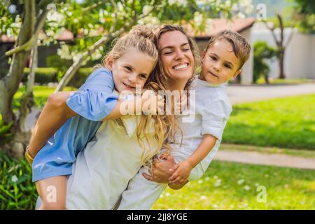 Famille heureuse à l'extérieur sur l'herbe dans un parc, visages souriants, avoir amusant Portrait d'une fille mécontente assis à une table de café Banque D'Images