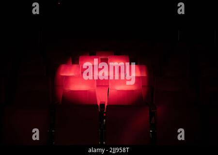 Sièges de théâtre rouge Emply avec cercle de spot. Banque D'Images
