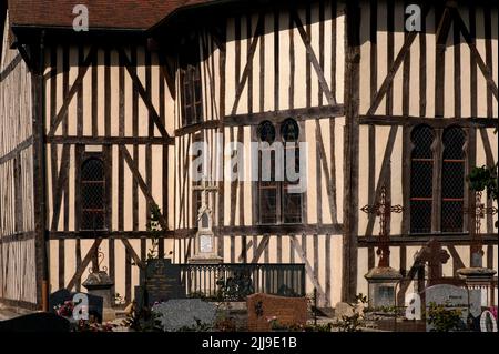 Des fenêtres en bois sculptées surmontées d'arches en fer à cheval éclairaient le choeur polygonal de l'église Saint-Nicolas, l'église du village restaurée datant des 16th et 17th siècles d'Outines, dans le pays du Der de la Marne, au Grand-est, en France. Le bâtiment est le plus grand et le plus monumental de toutes les églises historiques à colombages ou à pans de bois de la région de Champagne, avec d'énormes piliers et poutres en chêne soutenant son toit rouge recarrelé et des bardeaux en bois qui lui ajoutent sa spire mince. Banque D'Images