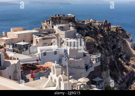 Bâtiments blanchis à la chaux et ruines du château d'Agios Nikolaos au bord de la falaise de la caldeira, village d'Oia, Santorin, Grèce, Europe Banque D'Images