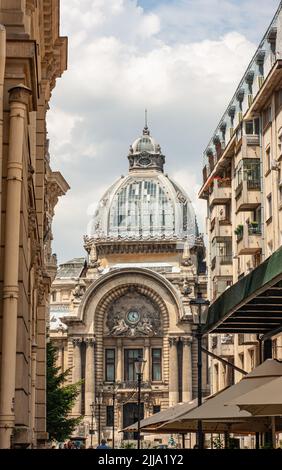 L'ancien bâtiment de la Bourse roumaine avec horloge décorative et dôme se trouve dans la vieille ville de Bucarest, en Roumanie, dans une rue animée. Banque D'Images