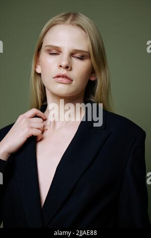 Un portrait rapproché d'une belle fille posant dans un studio sur un fond vert Banque D'Images