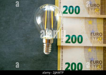 Coût de l'électricité. Ampoule, billets et pièces en euros .augmentation du coût de la lumière et de la chaleur.hausse des prix de l'électricité en Europe.économie d'électricité Banque D'Images