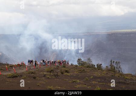 Les foules se sont rassemblées au parc national des volcans d'Hawaii pour observer un volcan actif avec de la fumée et de la vapeur s'élevant du cratère au loin Banque D'Images