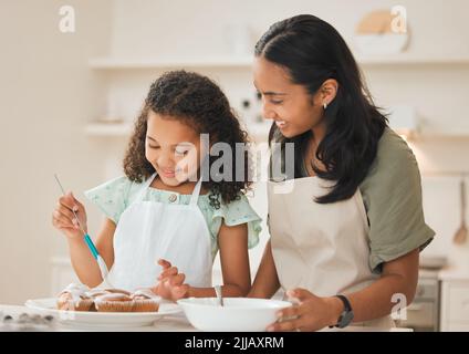 J'espère que le glaçage n'est pas trop sucré. Une mère et une fille ont fait des petits gâteaux fraîchement cuits. Banque D'Images