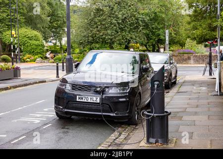 Le modèle hybride noir Range Rover Sport est chargé par un chargeur de voiture électrique à Whalley, près de Clitheroe, Lancashire, Royaume-Uni Banque D'Images